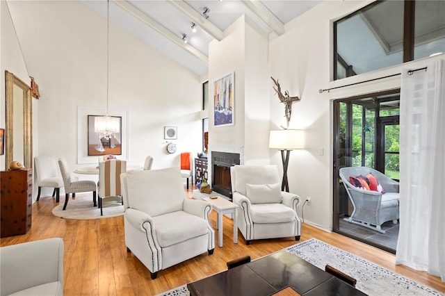 living room with a chandelier, a towering ceiling, and hardwood / wood-style floors