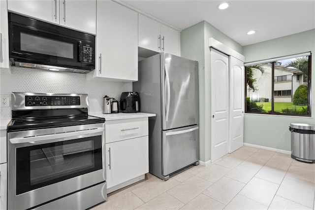 kitchen featuring light tile patterned flooring, appliances with stainless steel finishes, backsplash, and white cabinets