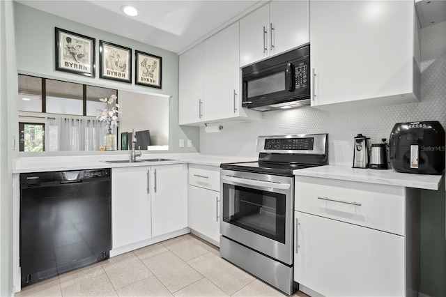 kitchen featuring black appliances, decorative backsplash, sink, light tile patterned flooring, and white cabinets