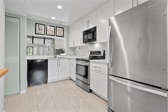 kitchen with sink, white cabinets, black appliances, and light tile patterned flooring