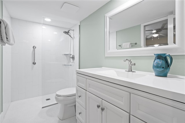 bathroom featuring toilet, vanity, tiled shower, and tile patterned flooring