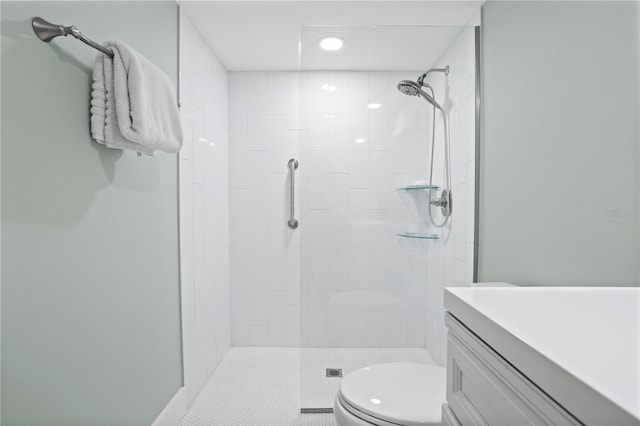 bathroom with toilet, vanity, and a tile shower