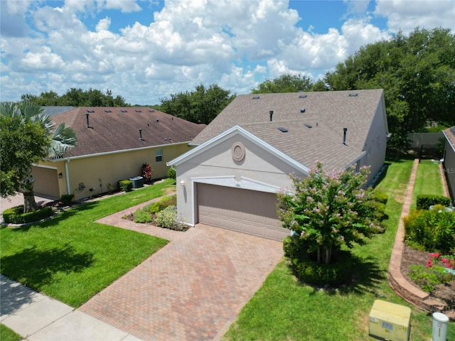 single story home featuring a garage, central air condition unit, and a front lawn