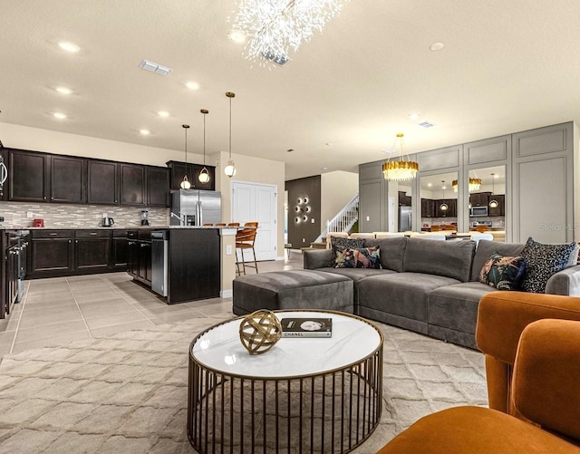 living room featuring light tile patterned floors and an inviting chandelier