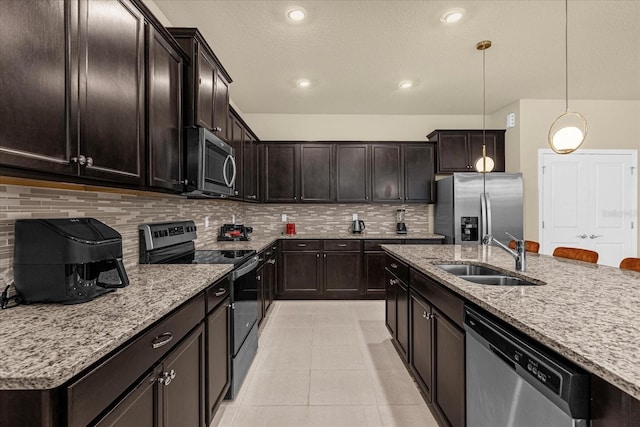 kitchen featuring light tile patterned floors, appliances with stainless steel finishes, decorative backsplash, decorative light fixtures, and sink