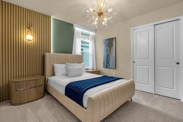 bedroom featuring a notable chandelier, carpet floors, and a closet