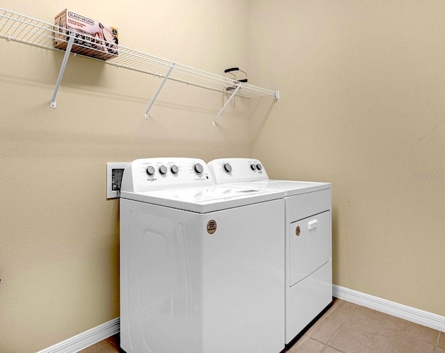 clothes washing area featuring washing machine and dryer and light tile patterned floors