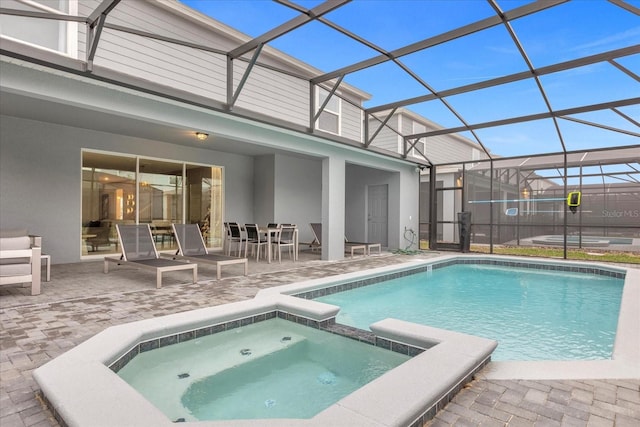 view of swimming pool featuring an in ground hot tub, a patio, and a lanai