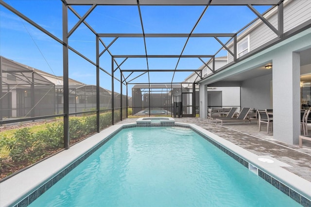 view of pool featuring an in ground hot tub, a patio, and glass enclosure