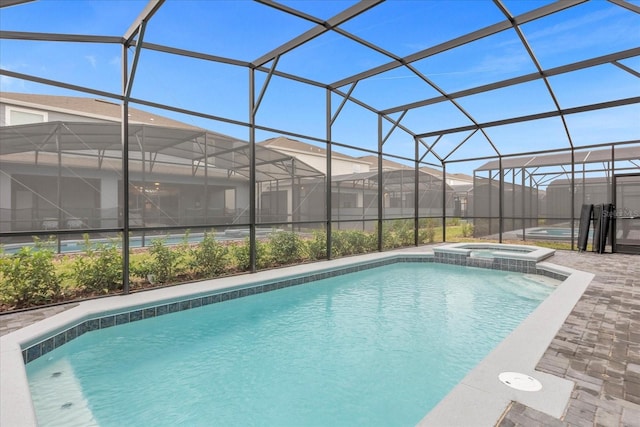 view of pool featuring an in ground hot tub, glass enclosure, and a patio area