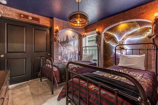 bedroom featuring brick wall, carpet flooring, and a textured ceiling