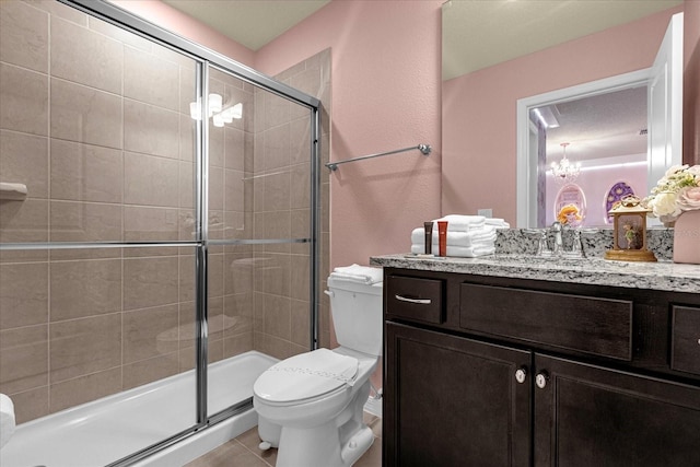 bathroom featuring vanity, walk in shower, an inviting chandelier, toilet, and tile patterned flooring