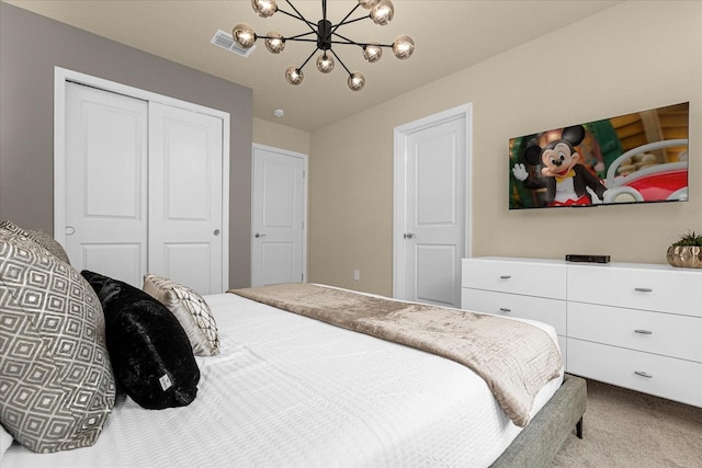 bedroom with a closet, carpet, and a chandelier