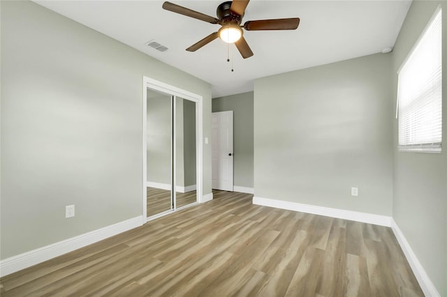 unfurnished bedroom featuring a closet, ceiling fan, and light hardwood / wood-style flooring