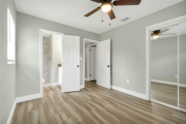 unfurnished bedroom featuring ceiling fan, a closet, ensuite bath, and light hardwood / wood-style flooring