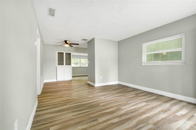 unfurnished room featuring ceiling fan, light hardwood / wood-style flooring, and a textured ceiling