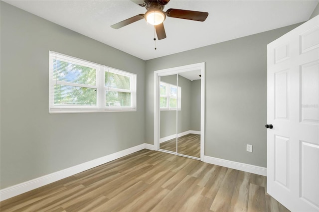 unfurnished bedroom with light hardwood / wood-style floors, a closet, and ceiling fan