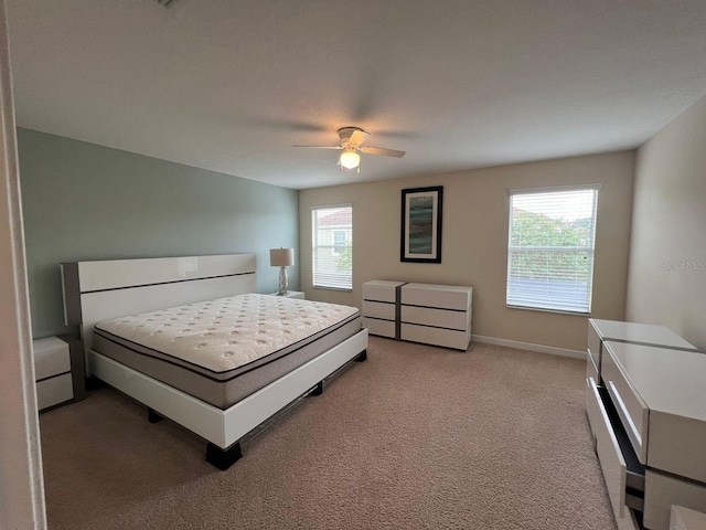 bedroom with ceiling fan, multiple windows, and carpet floors