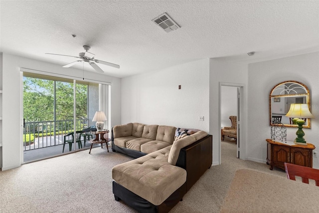 living room with a textured ceiling, carpet flooring, and ceiling fan