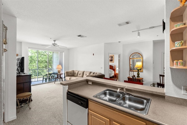 kitchen featuring a textured ceiling, dishwashing machine, sink, light colored carpet, and ceiling fan