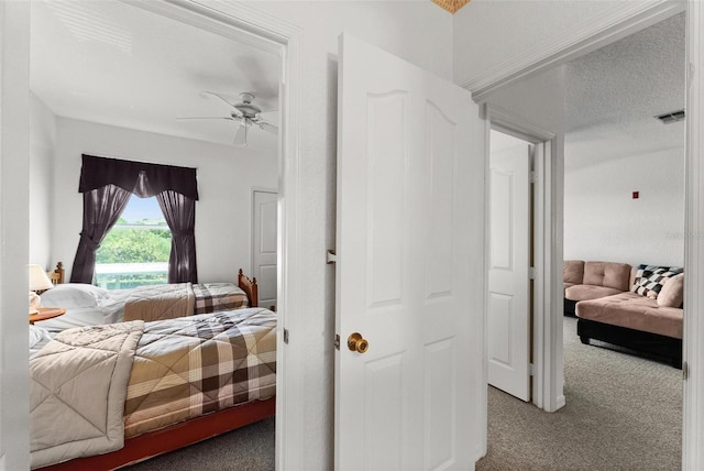 bedroom with a textured ceiling, carpet, and ceiling fan