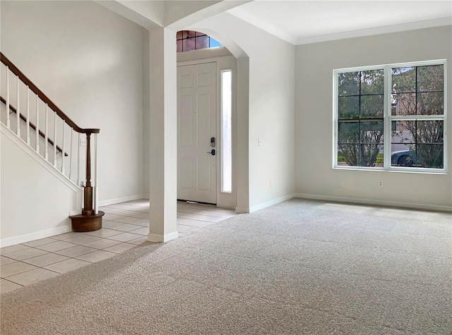 carpeted entrance foyer featuring ornamental molding