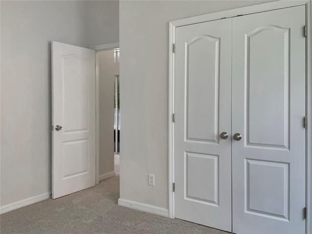 unfurnished bedroom with light carpet and a closet