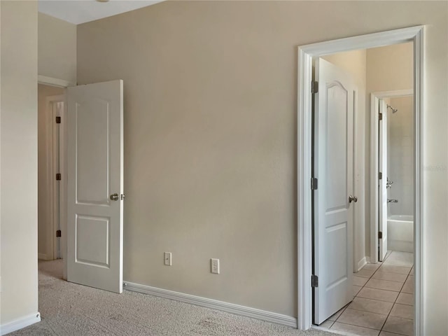 interior space with ensuite bathroom and light tile patterned floors