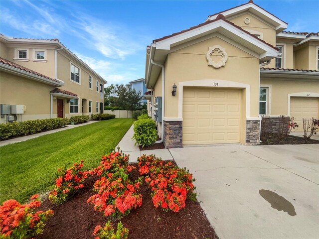 mediterranean / spanish-style home with a garage and a front lawn