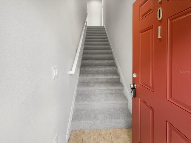 staircase featuring tile patterned flooring