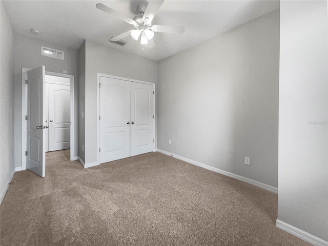 unfurnished bedroom with ceiling fan, a closet, and carpet floors