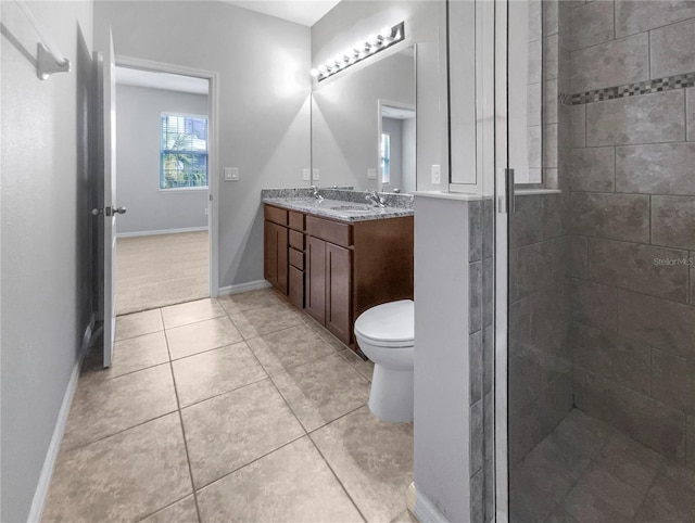 bathroom with tile patterned floors, vanity, toilet, and a shower with door