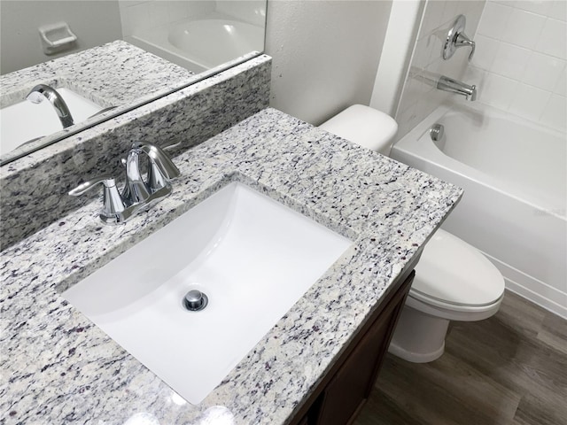 bathroom featuring shower / bathtub combination, vanity, toilet, and wood finished floors