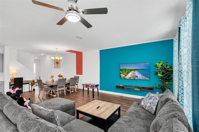 living room featuring ceiling fan with notable chandelier and hardwood / wood-style flooring