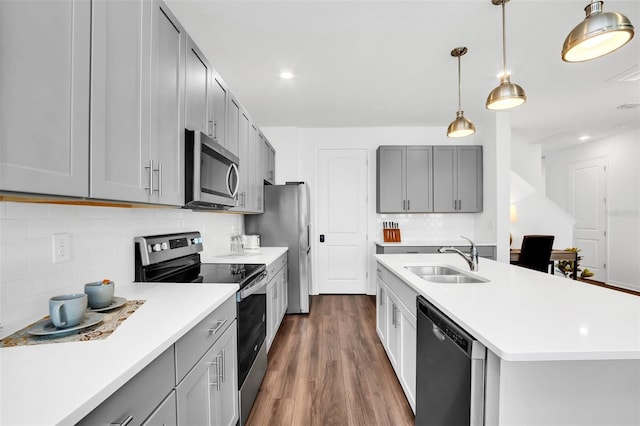 kitchen with sink, dark hardwood / wood-style flooring, stainless steel appliances, and backsplash