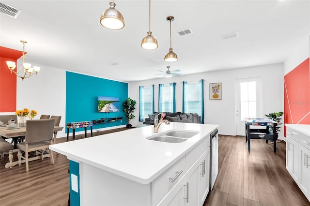 kitchen featuring white cabinetry, wood-type flooring, pendant lighting, sink, and a kitchen island with sink