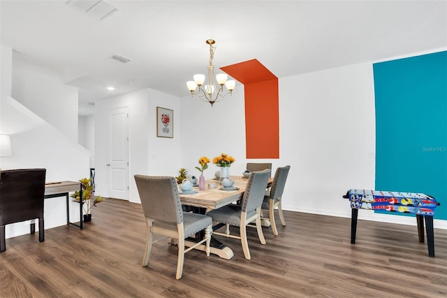 dining area featuring dark wood-type flooring and a notable chandelier