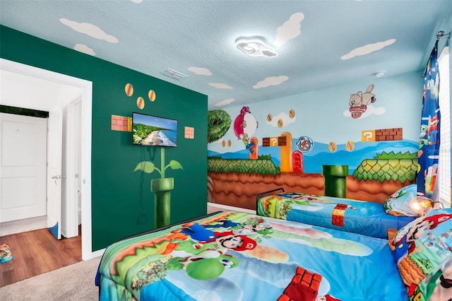 bedroom featuring a textured ceiling and hardwood / wood-style flooring