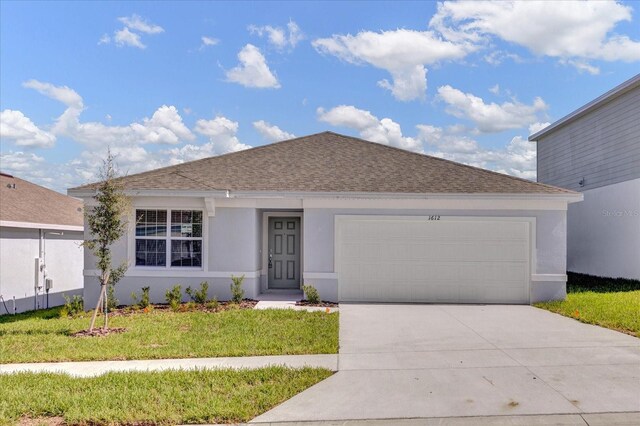 ranch-style house featuring a garage and a front lawn