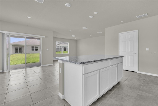 kitchen featuring white cabinets, light tile patterned floors, and a kitchen island