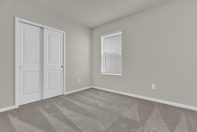 unfurnished bedroom with a closet and carpet flooring