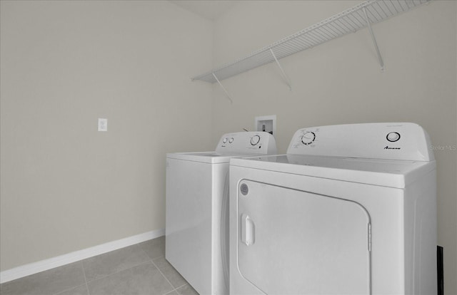 clothes washing area featuring washer and clothes dryer and light tile patterned floors