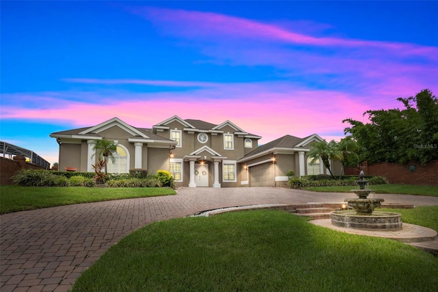 view of front of home with a garage and a lawn