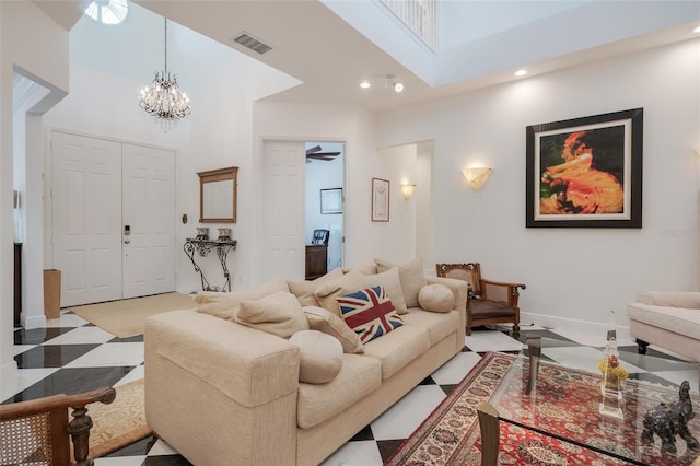 tiled living room with ceiling fan with notable chandelier and a towering ceiling