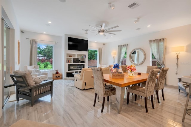 dining space with built in features, light hardwood / wood-style flooring, and ceiling fan