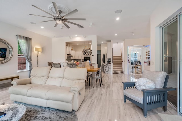 living room with ceiling fan and light hardwood / wood-style floors