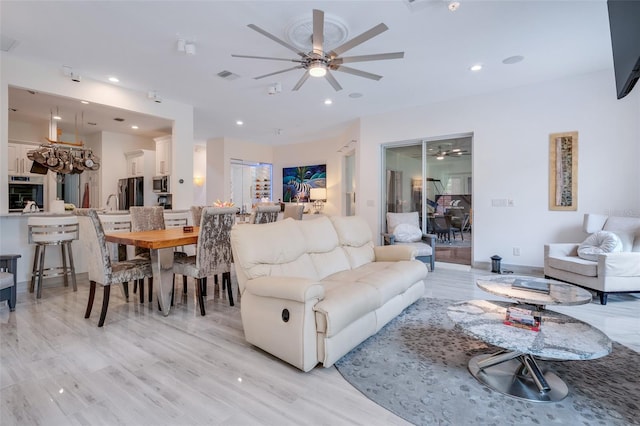 living room with light hardwood / wood-style flooring and ceiling fan