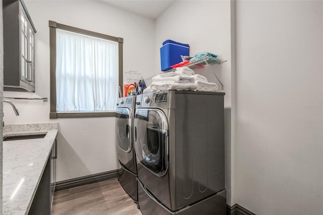 laundry area with sink, hardwood / wood-style flooring, and independent washer and dryer