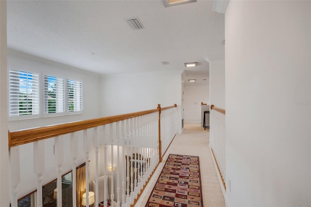 hall with light colored carpet