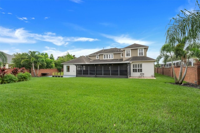 back of property featuring a sunroom and a yard